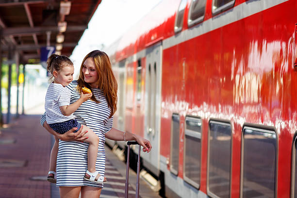 istock Cute little girl and mother on a railway station. 587228564