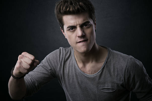 Young aggressive man showing fists and looking at camera