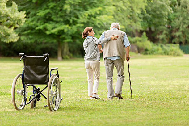 istock Senior man with caregiver at the park 587505632