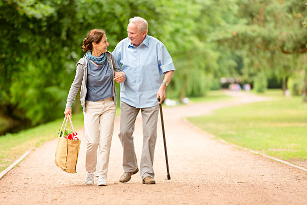 Caregiver – woman helping senior man with shopping stock photo