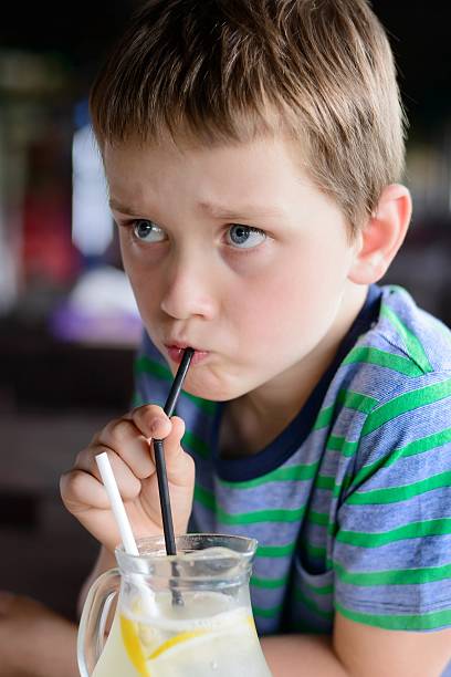 istock Little 7 years old boy child drinking cold lemonade 587507872