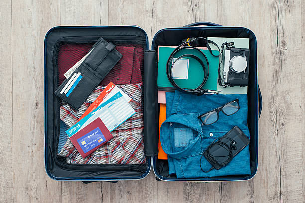 Traveler's bag Open traveler's bag with clothing, accessories, credit card, tickets and passport, travel and vacations concept knolling concept stock pictures, royalty-free photos & images