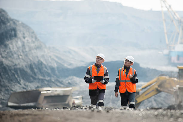 Workers with coal at open pit Two speacialists examining coal at an open pit metal ore stock pictures, royalty-free photos & images