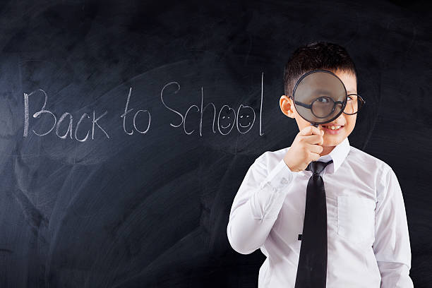 istock Boy with magnifier and text Back to School 587514116