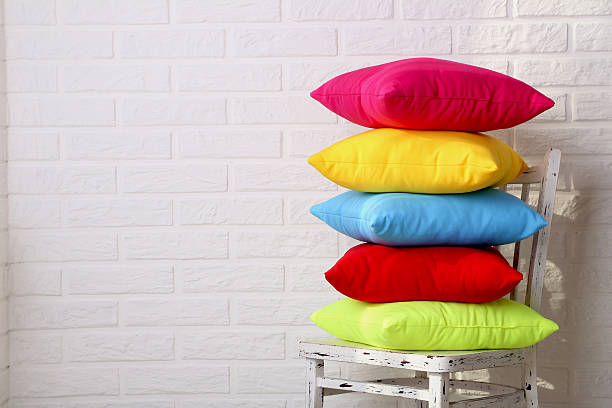 istock Colorful pillows on chair on white brick wall background 587515824