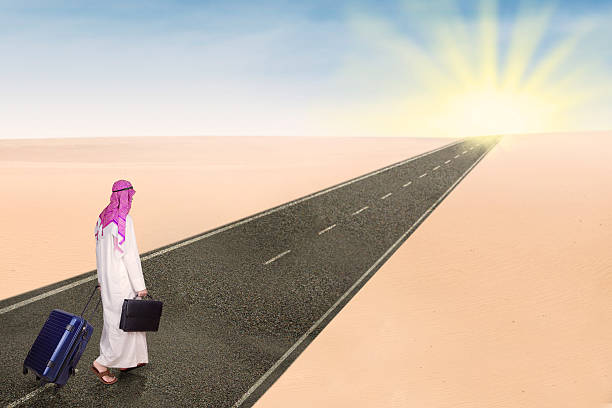 istock Arabic person with suitcase walking on street 587516818