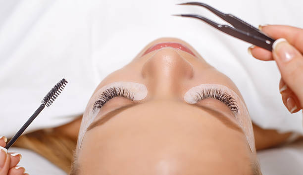 eyelash extension procedure. woman eye with long eyelashes. lashes. - make up women ceremonial makeup senior women imagens e fotografias de stock