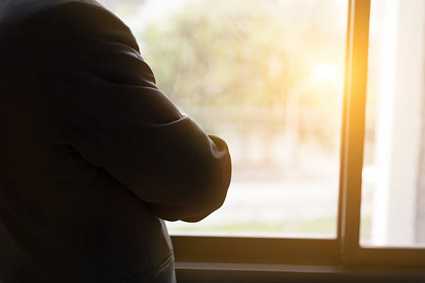 istock businessman in suit looking through office window 587518622