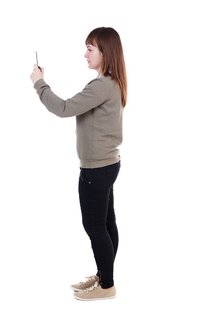 istock back view of standing young beautiful  woman  using a mobile 587520706