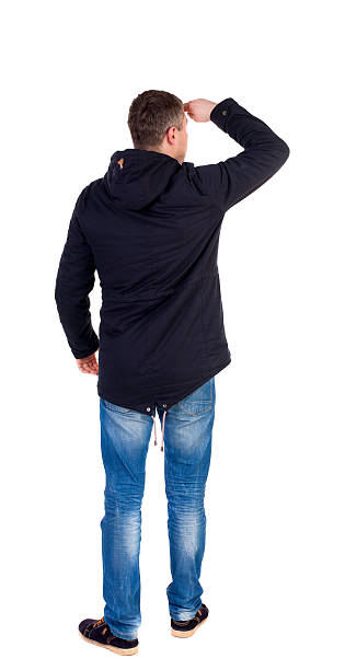 istock Back view of handsome man in winter jacket  looking up. 587521422