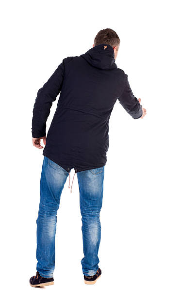 istock man in jacket holds out his hand for handshake. 587521528
