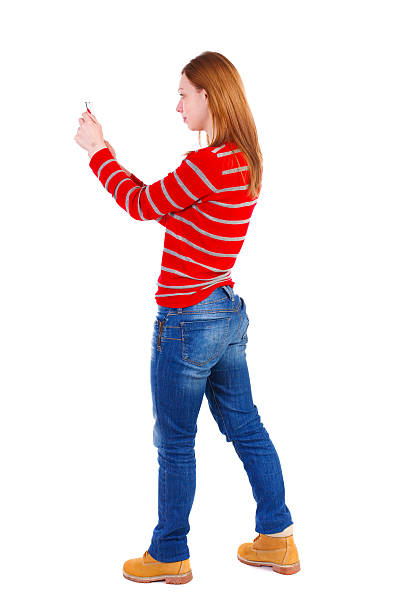 istock back view of standing young beautiful  woman  using a mobile 587522904