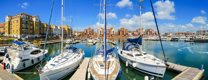 Panoramic view of Sovereign Harbour Marina with moored yachts and luxury houses. Eastbourne, East Sussex, England
