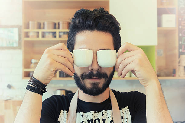bartender holding cups of coffee like a glasses.