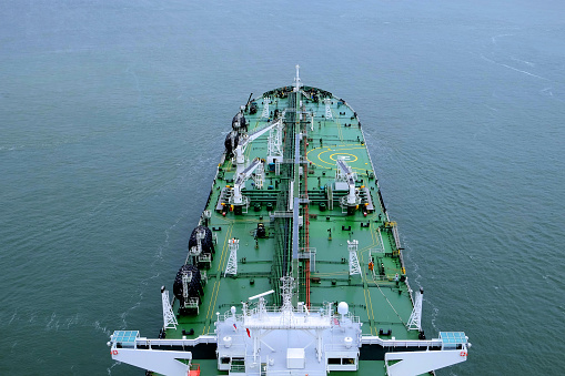 Aerial view of crude oil tanker ship sailing in calm seas.  The deck of the modern Suezmax vessel looks very clean and tidy as it passes underneath the camera. Horizontal, logos & ID removed.