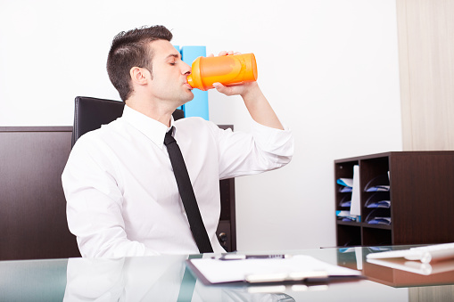 modern businessman shaking and drinking  protein drink after gym training