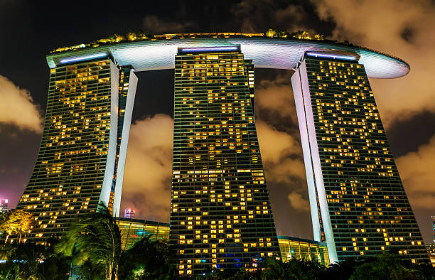 Singapore, Singapore - February 29, 2016: Marina Bay Sands Hotel and Casino at Downtown Core at night. Cityscape of luxury resort with swimming pool illuminated with light.