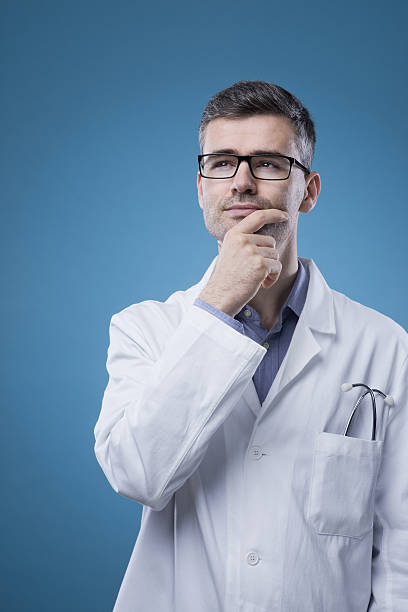 istock Pensive doctor with hand on chin 587528614