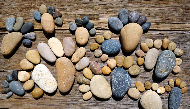 Abstract cute concept on wood background from pebbles, amazing arranged boulder to family of footprint, awesome shape from pebblestone