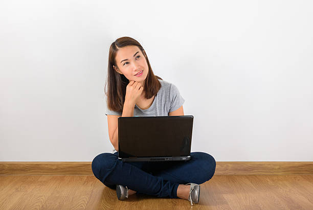 istock Young creative woman sitting in the floor with laptop 587530936