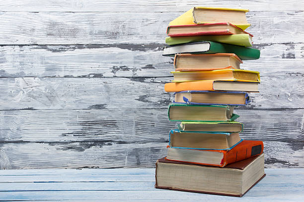 istock Stack of hardback books on wooden table. Back to school 587531422