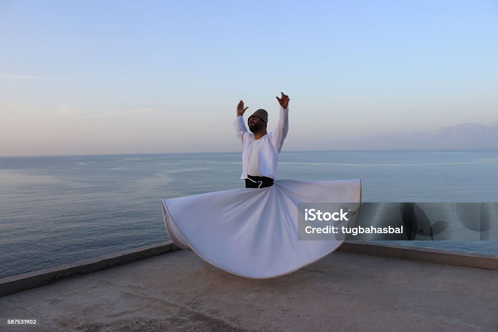 Only birds can fly? Antalya, Turkey - April 16, 2016: Whirling dervish (Ishak Urun) with the beautiful sea scenery of Antalya Sufism Stock Photo