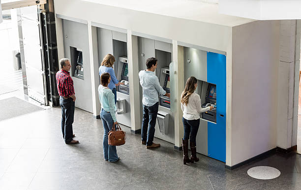 personas que retiran dinero en efectivo en un cajero automático - banco edificio financiero fotografías e imágenes de stock