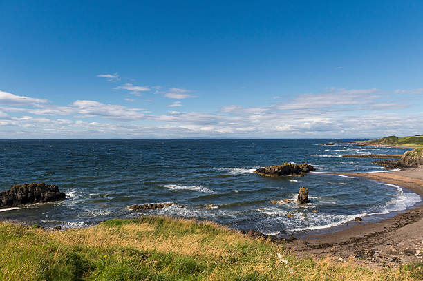 Waves crashing against rocks on the Ayrshire coastline in Scotland during summer