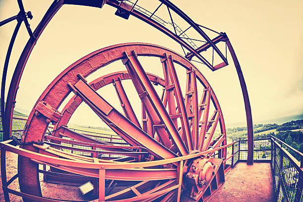 Vintage stylized fisheye lens photo of a mine shaft pulley wheel. Industrial detail background.