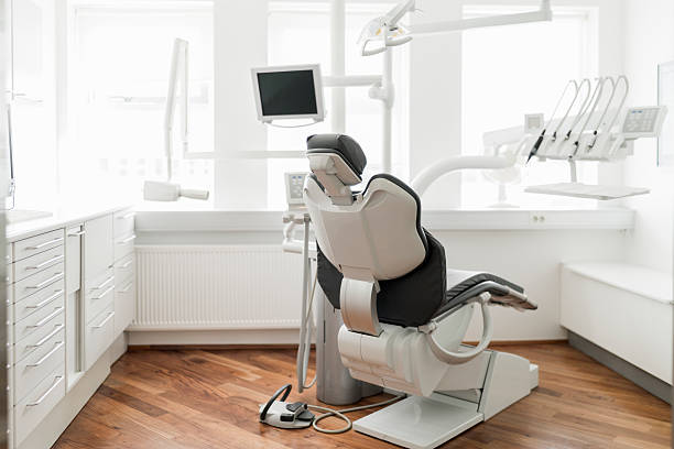 кресло стоматолога в ярко освещенной клинике - dentist office dentists chair chair nobody стоковые фото и изображения