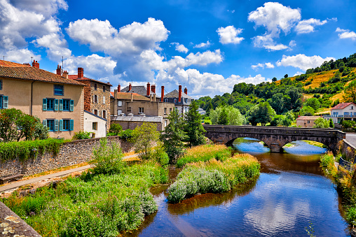 French city: Saint-Flour in East France. Old stone houses near small lazy river and church an houses on top of the hill. Typical scenery from small french city in South East France.