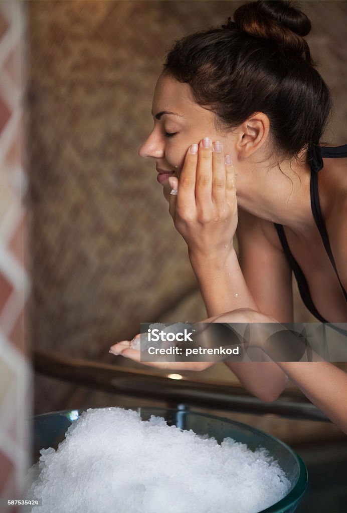 Beautiful happy woman with natural looking makeup holding ice ne Beautiful happy woman with natural looking makeup holding ice near her face. Spa concept Adult Stock Photo
