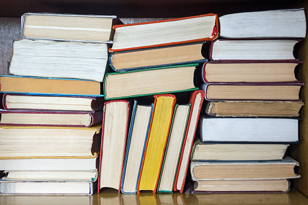 istock Books on grunge wooden table desk shelf in library. Back 587535736