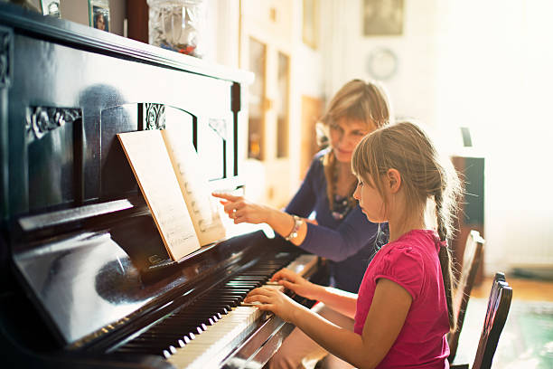 little girl practicing piano - practicing piano child playing imagens e fotografias de stock