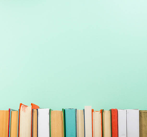 Books on grunge wooden table desk shelf in library. Back Colorful composition with vintage old hardback books, diary on wooden deck table and yellow background. Books stacking. Back to school. Copy Space. Education background rows of books stock pictures, royalty-free photos & images