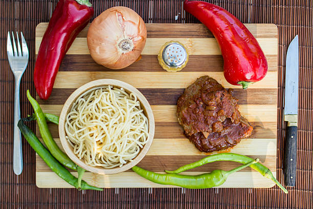 beef with tomato sauce, sphagetti and vegetables. - salisbury steak imagens e fotografias de stock
