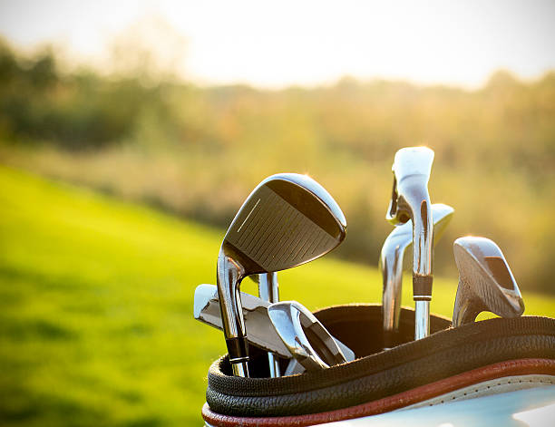 golf clubs drivers over green field background - golfclub stockfoto's en -beelden