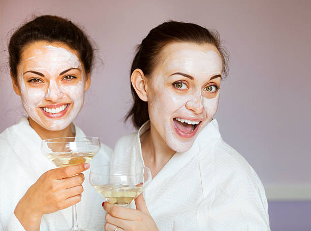 istock Young happy female friends drinking champagne in spa 587538280