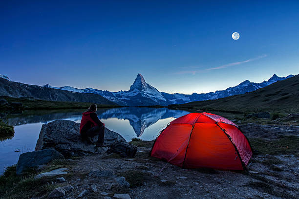 Camper under full Moon at Matterhorn An illuminated tent under full Moon at Matterhorn in Switzerland red full moon stock pictures, royalty-free photos & images