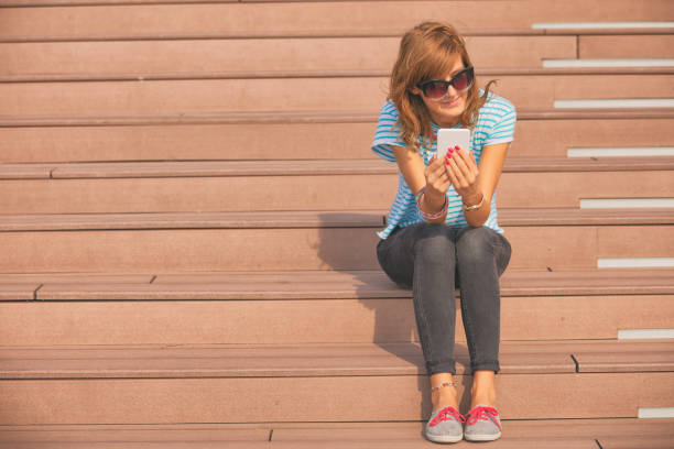Girl using cellphone outdoors.