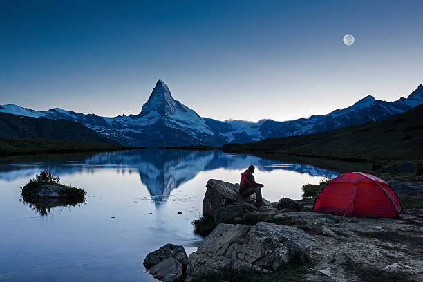 Camper under full Moon at Matterhorn An illuminated tent under full Moon at Matterhorn in Switzerland red full moon stock pictures, royalty-free photos & images