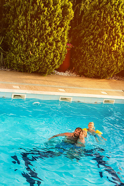 istock Father and sons in swimming pool 587544094