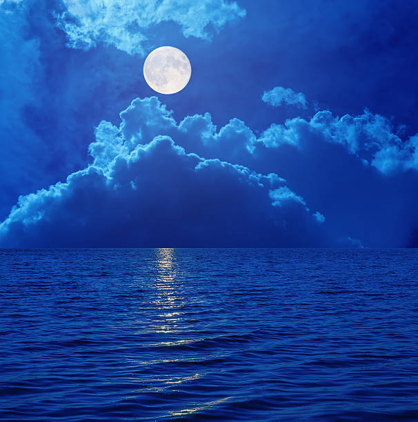istock super moon in sky with clouds over sea 587544620