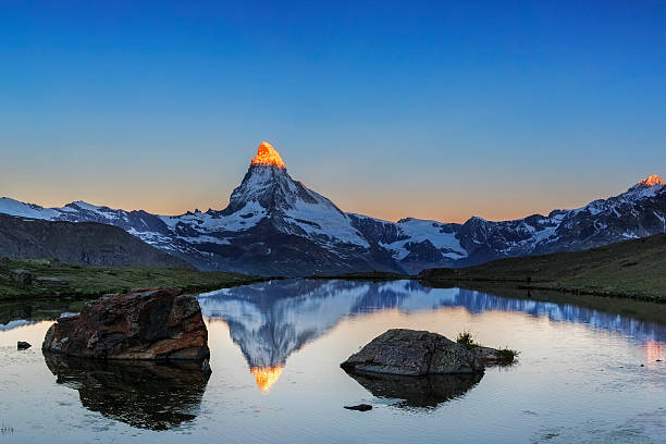 alpen leuchten am matterhorn mit stellisee im vordergrund - matterhorn stock-fotos und bilder