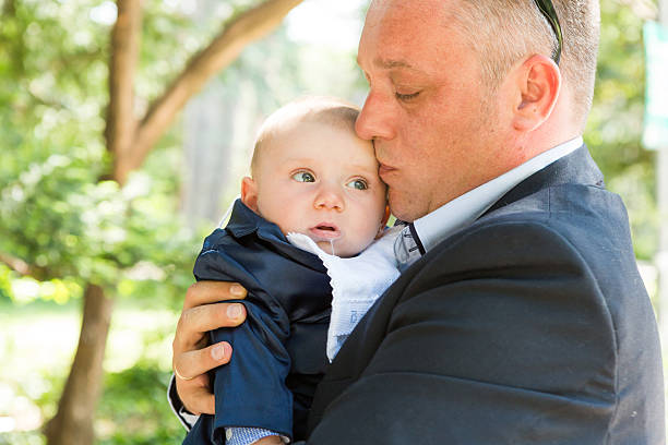 istock Baby boy is being held gently by his father 587545562