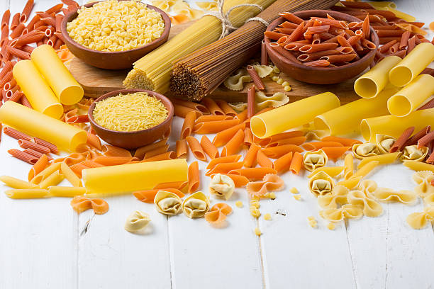 istock Differents types of pasta on the white wooden table. background 587546134