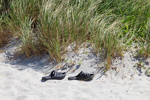 A pair of sandals on the beach.