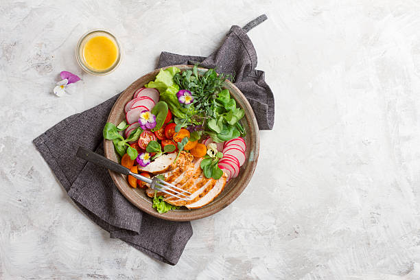 istock Spring salad with vegetables, chicken breast and edible flowe 587547812