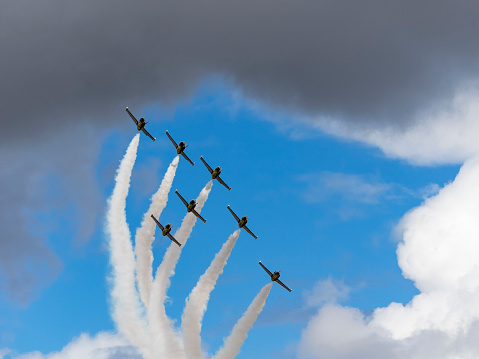 Hillsboro, Oregon, USA - August 7, 2016: The Breitling Jet Team was at the Oregon International Air show for the first time ever in August 2016. The team uses L-39C Albatros aircraft that are a Czech-Made twin-seater military training jet. This photo of one of the teams precision formations, has a beautiful mixture of blue sky with white and gray puffy clouds. The Air Show in Hillsboro, Oregon is a very popular event each year. This is a suburb of the city of Portland, Oregon.