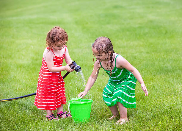istock Two Young Girls Playing With Water in Summer 587773320
